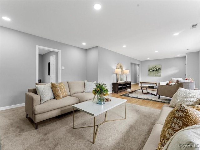 living room with baseboards, light wood finished floors, visible vents, and recessed lighting