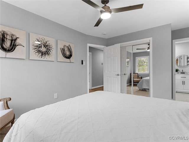 bedroom featuring a ceiling fan, a closet, and a sink