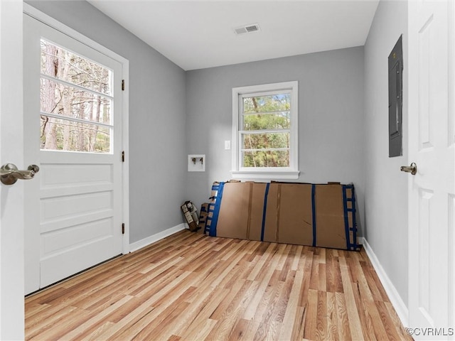 laundry area with a wealth of natural light, light wood-type flooring, and visible vents