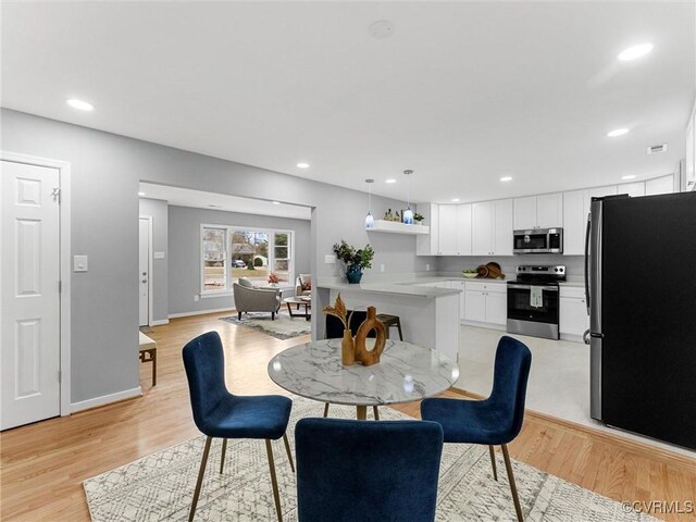 dining space with light wood-style floors, recessed lighting, and baseboards