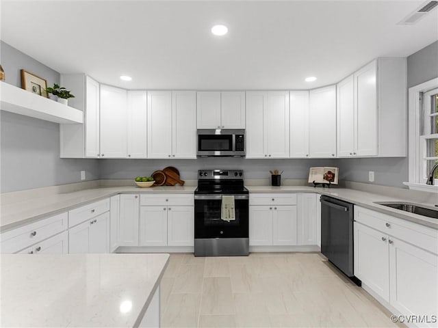 kitchen with stainless steel appliances, recessed lighting, white cabinetry, and a sink