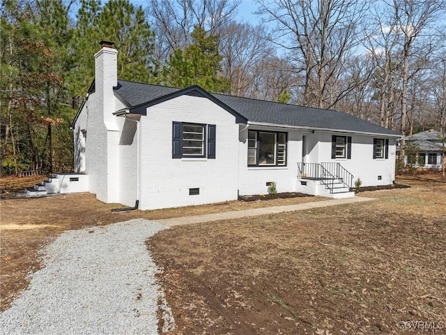 single story home featuring driveway, a shingled roof, a chimney, crawl space, and brick siding