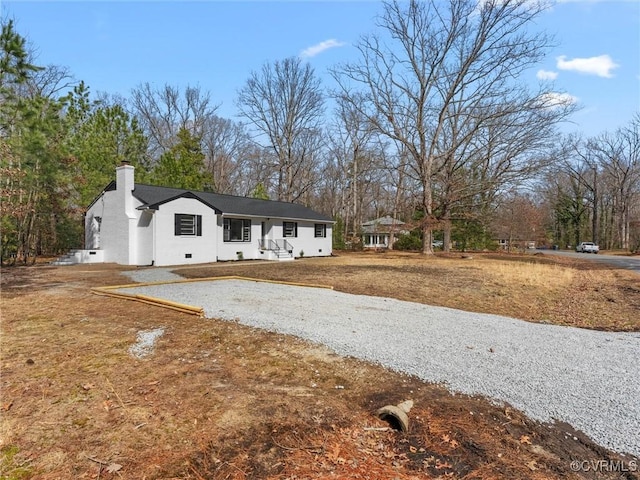 single story home featuring driveway and a chimney