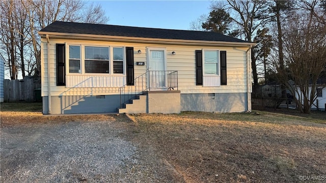 view of front of property featuring crawl space, gravel driveway, and fence