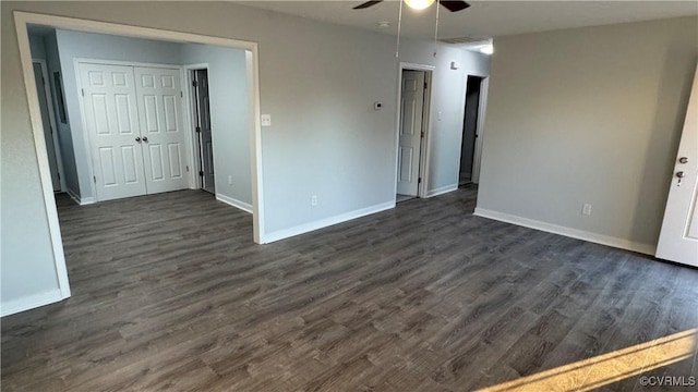 interior space with dark wood-style floors, baseboards, and a ceiling fan