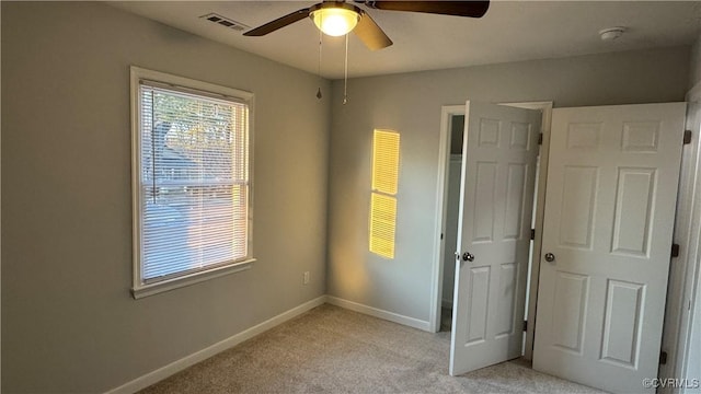 unfurnished bedroom with light carpet, baseboards, visible vents, and ceiling fan