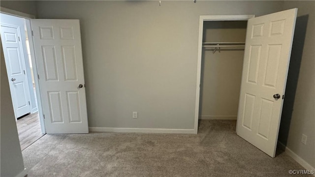 unfurnished bedroom with a closet, carpet flooring, and baseboards