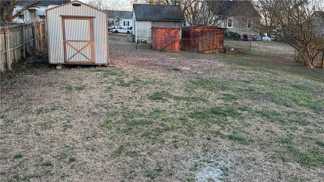 view of yard featuring a storage unit, an outdoor structure, and a fenced backyard