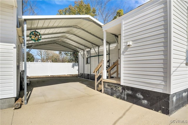 view of car parking featuring a carport, fence, and driveway