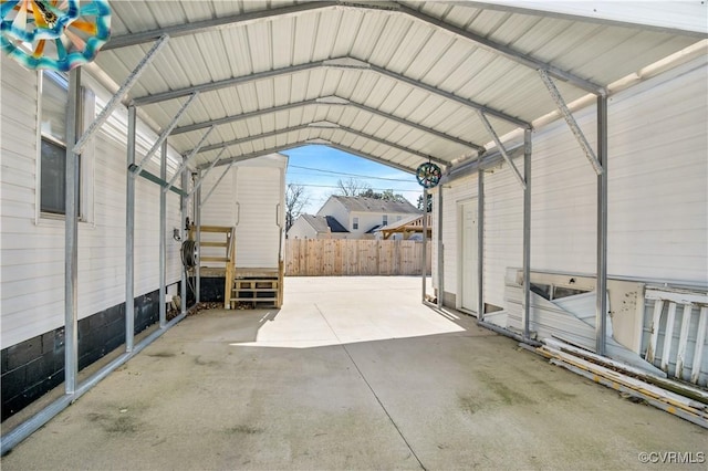 view of car parking with fence and a detached carport