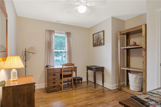 office space with light wood finished floors, baseboards, visible vents, and ceiling fan