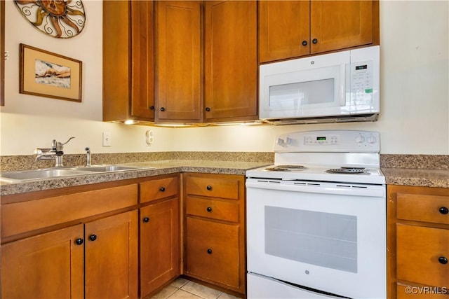 kitchen with white appliances, light tile patterned floors, brown cabinetry, light countertops, and a sink