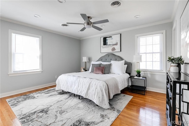 bedroom featuring baseboards, visible vents, wood finished floors, and ornamental molding