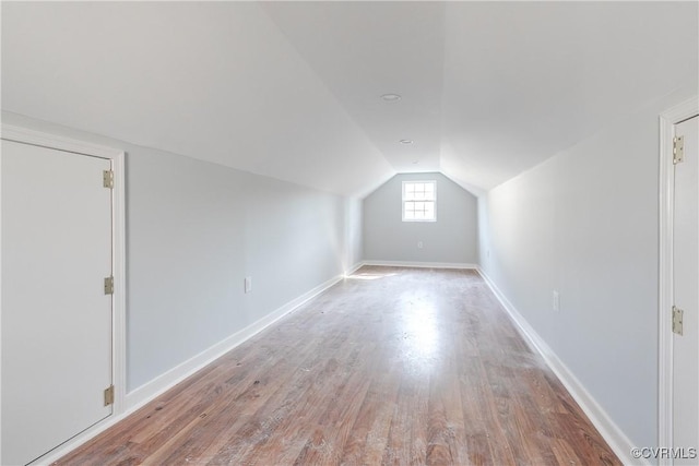 additional living space featuring vaulted ceiling, wood finished floors, and baseboards