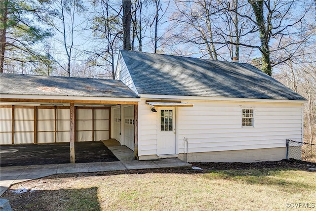 exterior space featuring driveway, an attached carport, and a lawn