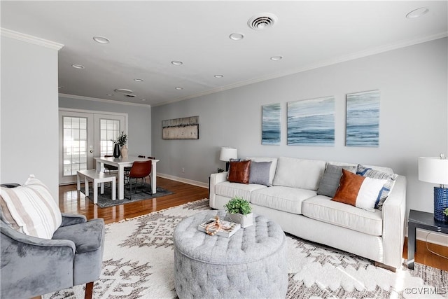 living room featuring french doors, crown molding, visible vents, wood finished floors, and baseboards