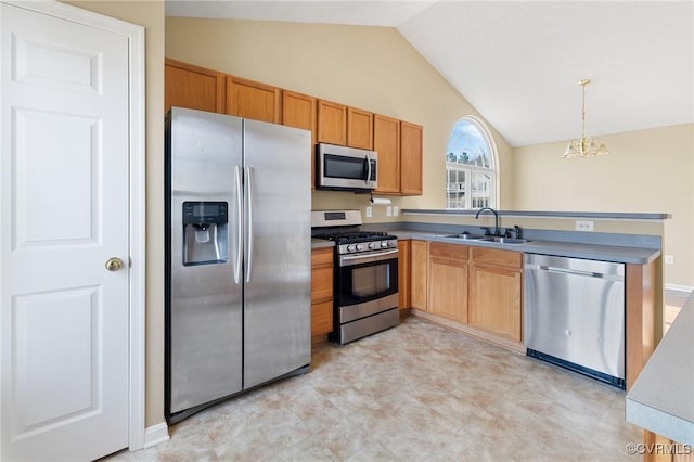 kitchen with stainless steel appliances, lofted ceiling, a sink, and hanging light fixtures