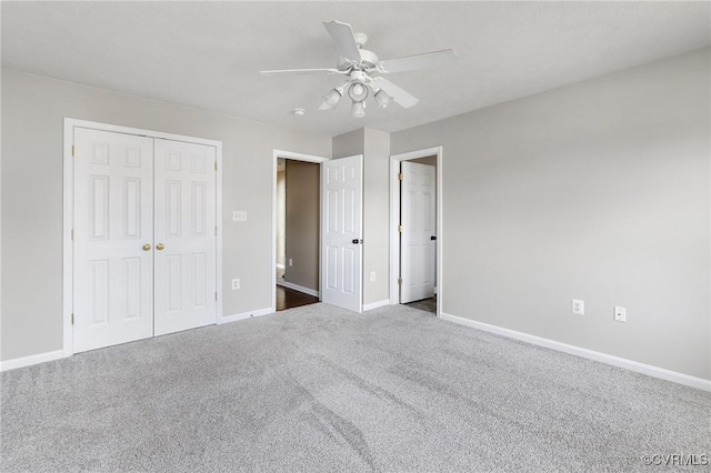 unfurnished bedroom featuring a ceiling fan, a closet, dark carpet, and baseboards