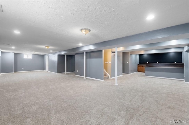 basement with baseboards, light colored carpet, stairway, and a textured ceiling