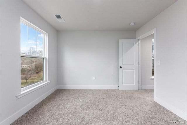 spare room featuring visible vents, baseboards, and carpet