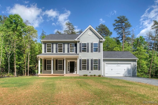 colonial-style house featuring a porch, a garage, driveway, roof with shingles, and a front lawn