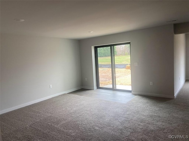 empty room featuring light colored carpet and baseboards