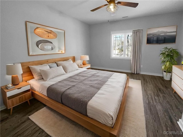 bedroom with dark wood-style flooring, a ceiling fan, and baseboards