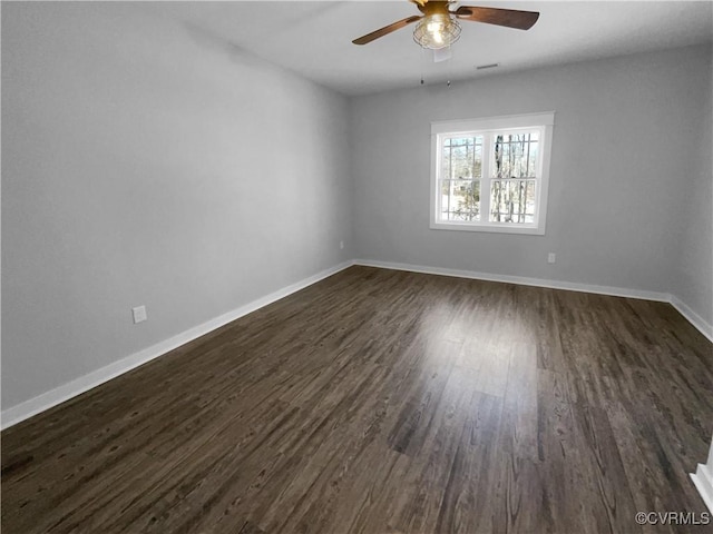 empty room with ceiling fan, baseboards, and dark wood-type flooring