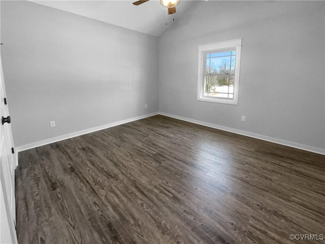 unfurnished room with a ceiling fan, dark wood-style flooring, vaulted ceiling, and baseboards