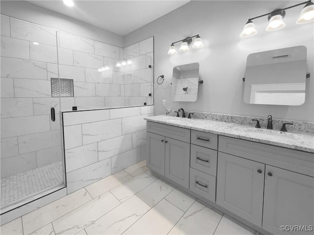 full bath featuring double vanity, marble finish floor, a sink, and a stall shower