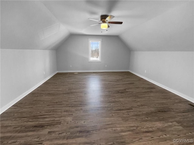 bonus room with lofted ceiling, ceiling fan, dark wood-style flooring, and baseboards