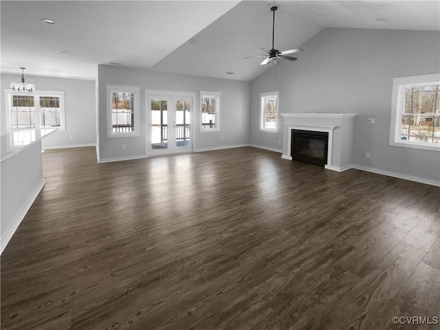 unfurnished living room featuring dark wood-type flooring, a glass covered fireplace, and a wealth of natural light