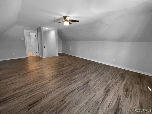 bonus room with dark wood-type flooring, vaulted ceiling, baseboards, and a ceiling fan