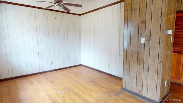 empty room featuring crown molding, baseboards, ceiling fan, and wood finished floors