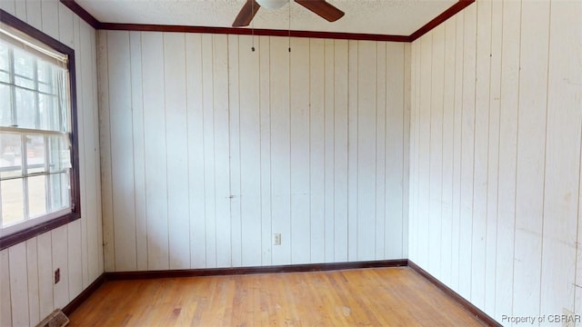 unfurnished room featuring a textured ceiling, a ceiling fan, light wood-style flooring, and baseboards