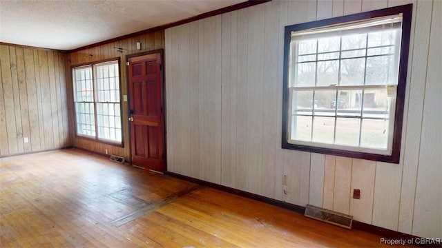 spare room featuring baseboards, visible vents, and hardwood / wood-style floors