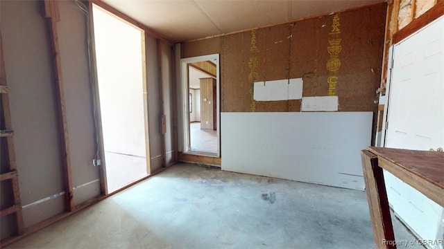 unfurnished room featuring unfinished concrete flooring