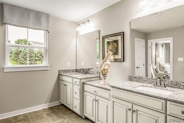 full bathroom featuring double vanity, visible vents, baseboards, and a sink