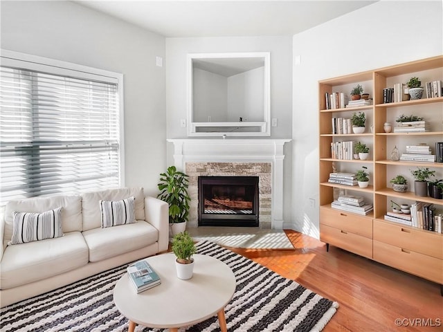 living area with a tile fireplace and light wood-style floors