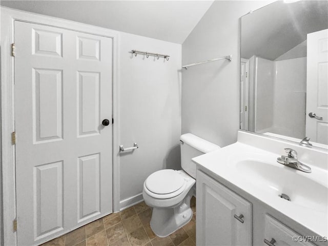 bathroom with toilet, vaulted ceiling, and vanity