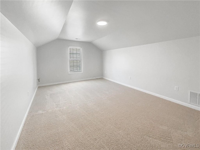 additional living space with lofted ceiling, carpet, visible vents, and baseboards