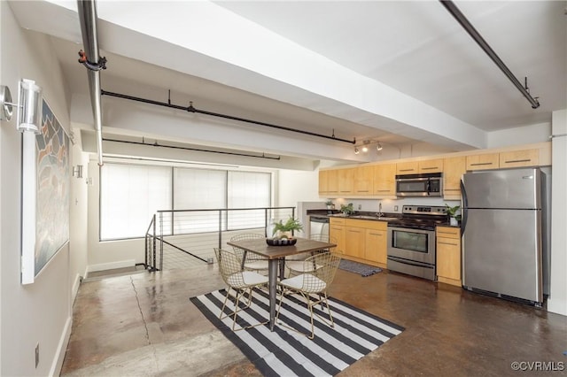 kitchen with finished concrete flooring, dark countertops, light brown cabinets, and stainless steel appliances