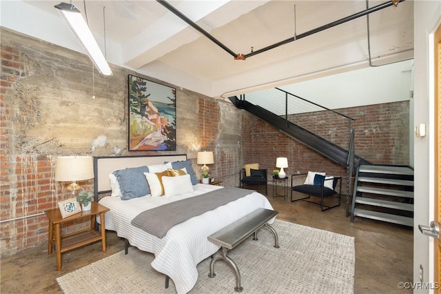 bedroom featuring finished concrete flooring and brick wall