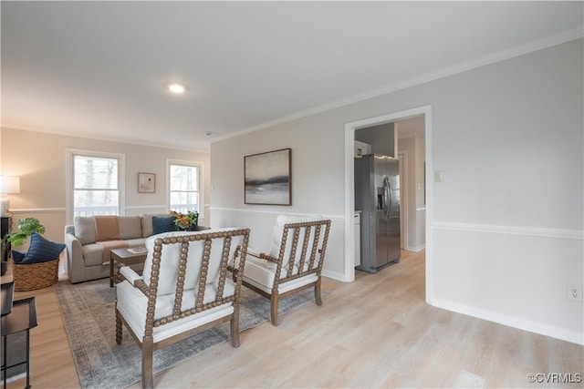 living area featuring light wood finished floors and crown molding