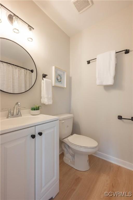 full bath with toilet, wood finished floors, vanity, visible vents, and baseboards