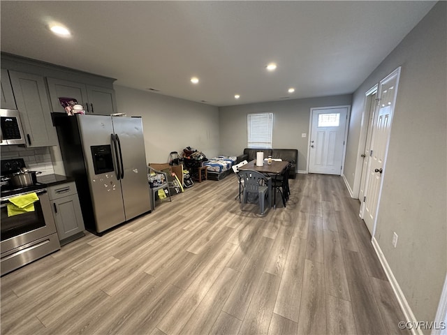 kitchen with recessed lighting, stainless steel appliances, backsplash, gray cabinets, and light wood finished floors