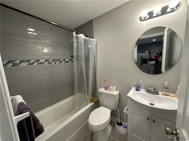 full bath featuring toilet, wood finished floors, vanity, baseboards, and shower / bath combo