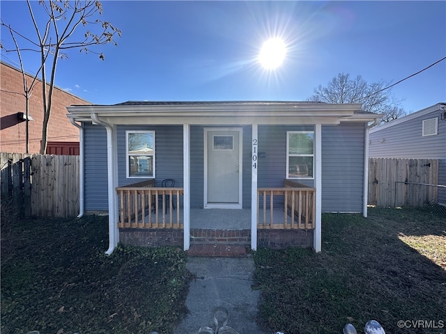 bungalow-style house with covered porch and fence