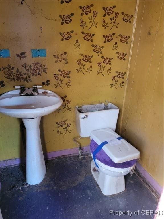 bathroom with a sink, toilet, and baseboards