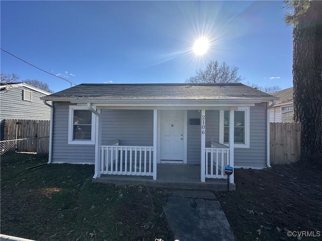 bungalow-style home featuring a porch and fence